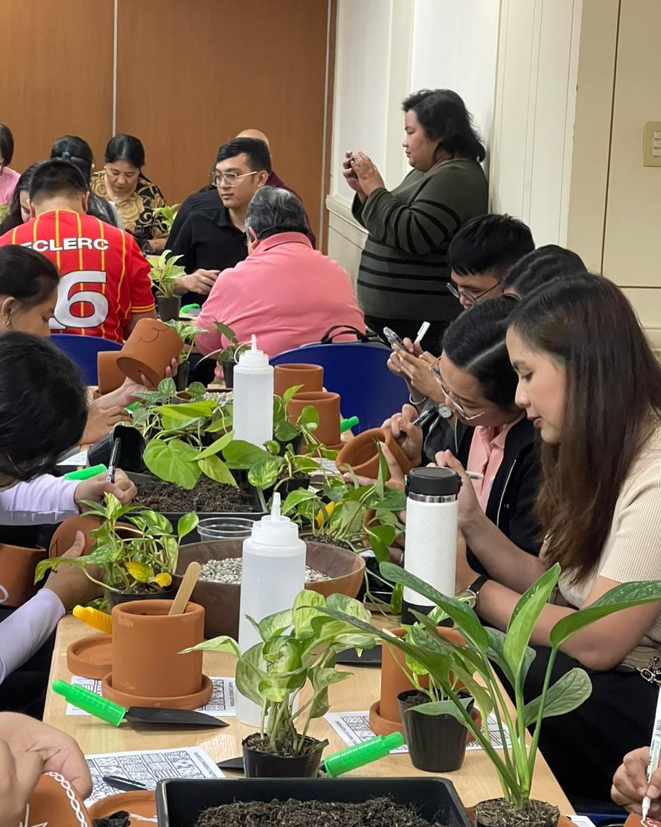 Workshop participants at table decorating terracotta pots